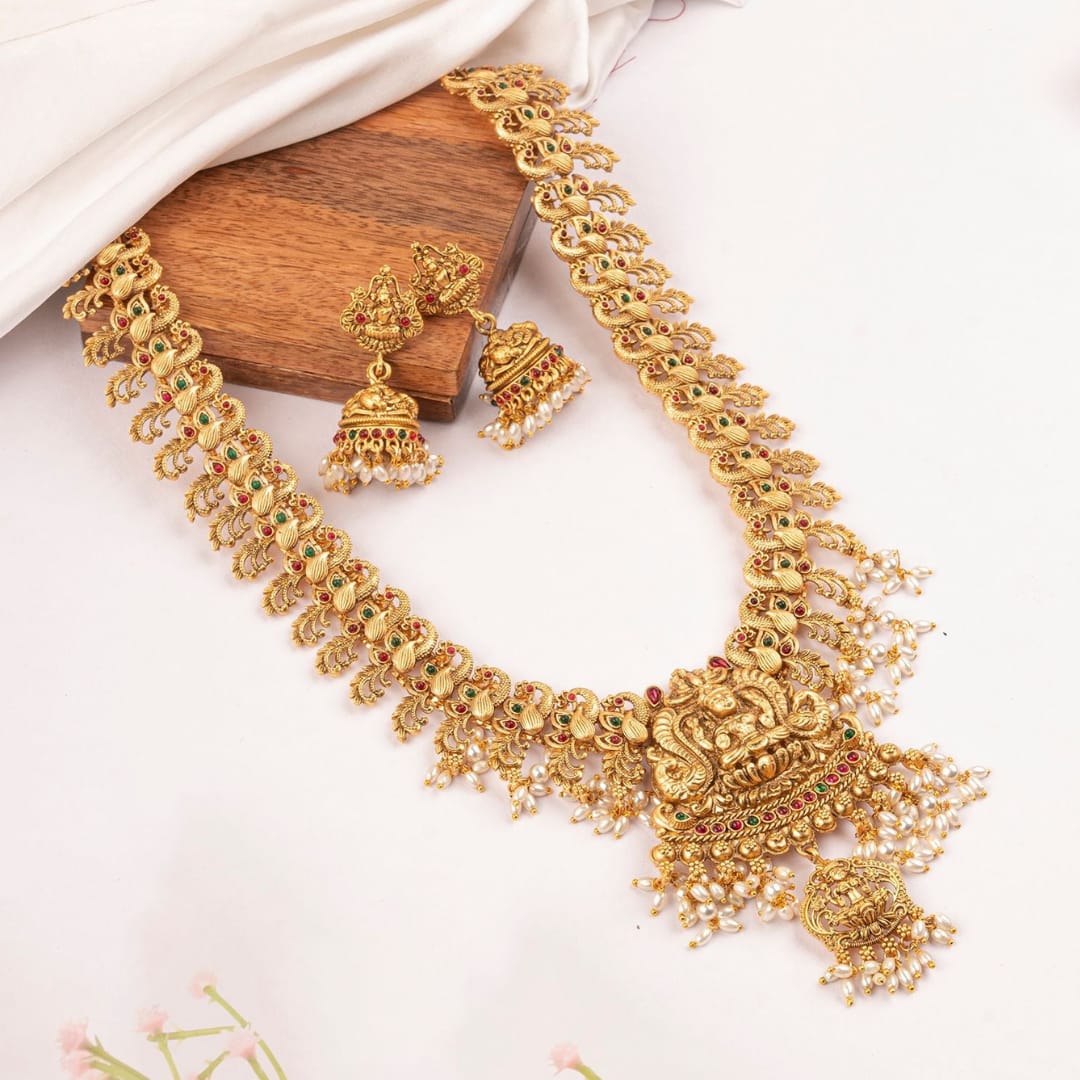 Gold necklace with matching earrings on a white background