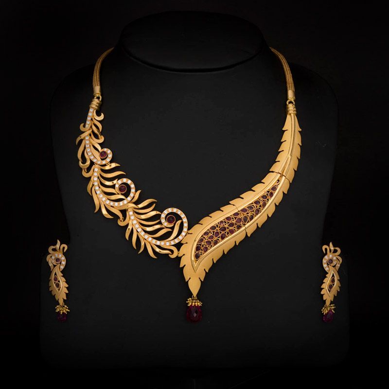 Gold necklace with red gemstones on a black background