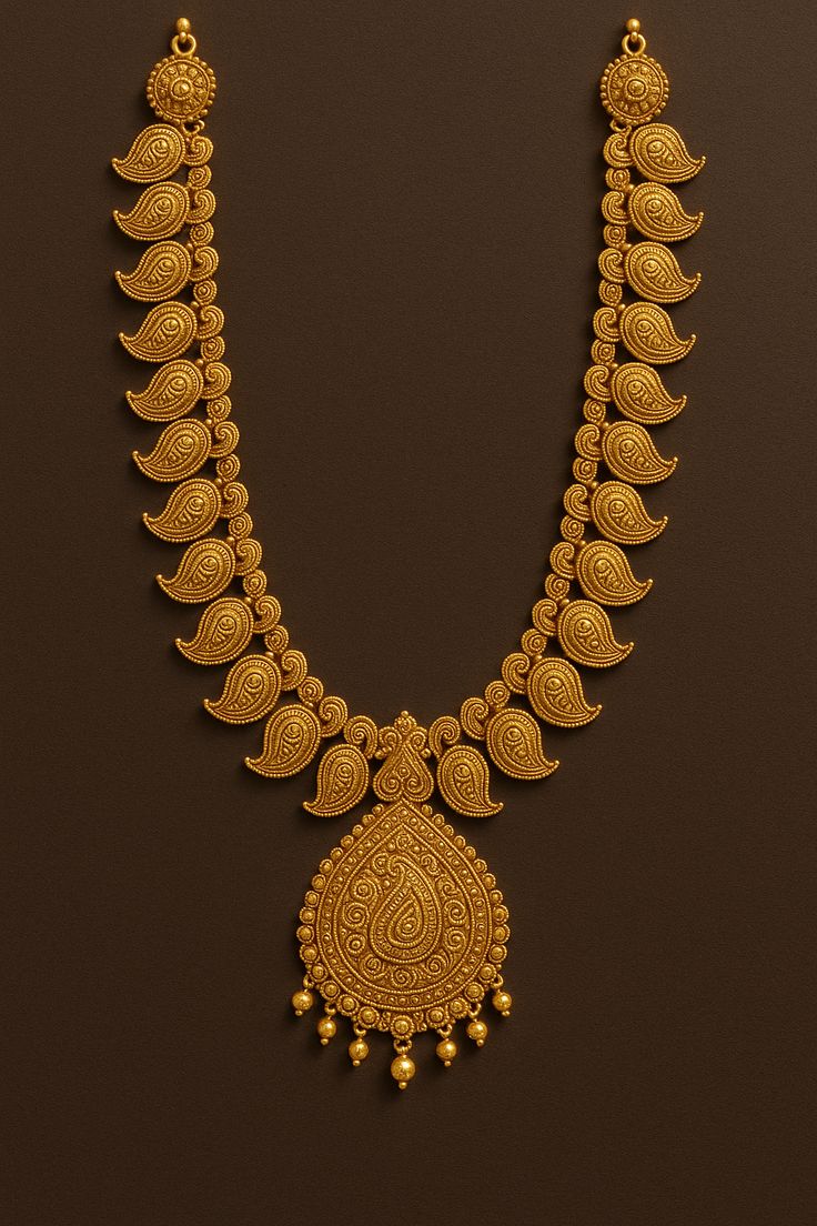 Gold necklace with intricate design on a brown background