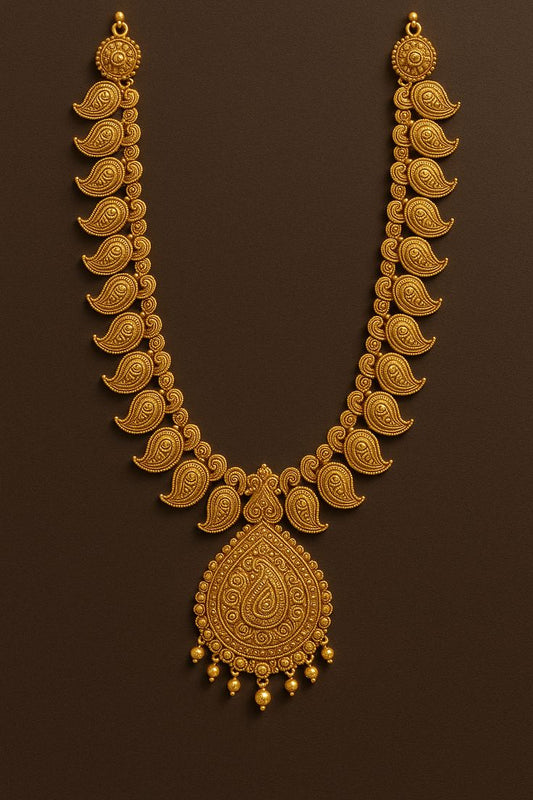 Gold necklace with intricate design on a brown background